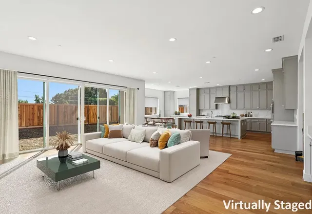 a living room with furniture kitchen view and large windows
