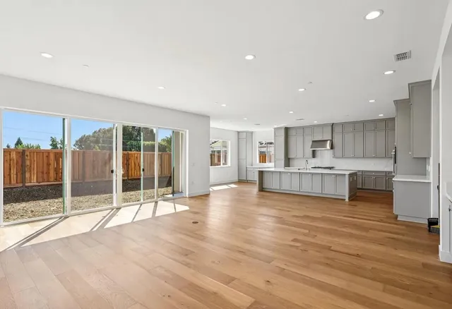 a view of a kitchen with wooden floor and windows