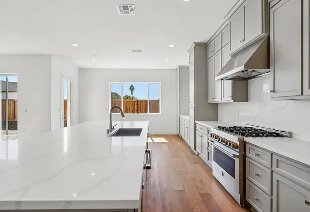 a kitchen with stainless steel appliances a stove a sink and a refrigerator