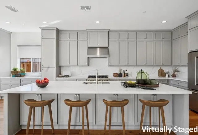 a kitchen with stainless steel appliances granite countertop a table chairs sink and cabinets