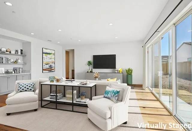 a living room with furniture a flat screen tv and a floor to ceiling window