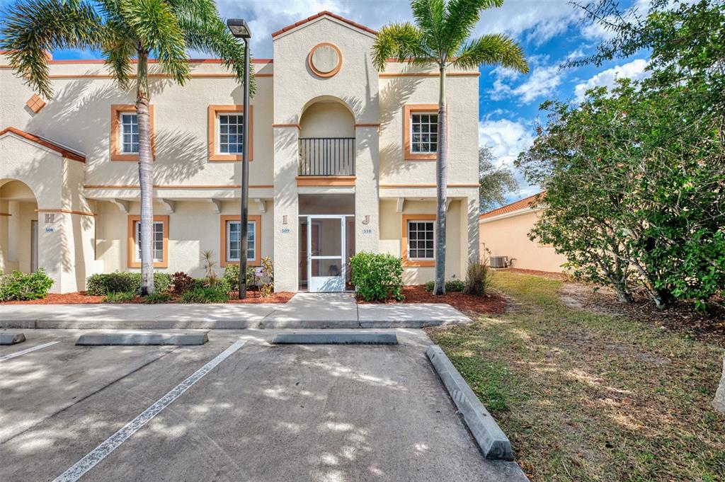 1246 Rio De Janeiro Avenue, Unit 510 Punta Gorda, FL 33983 - Photo 2 of 52 a view of a white house with a clock and a tree