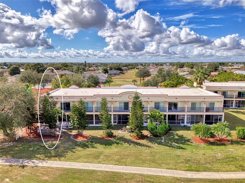 1246 Rio De Janeiro Avenue, Unit 510 Punta Gorda, FL 33983 - Photo 44 of 52 a view of a house with a big yard and large trees