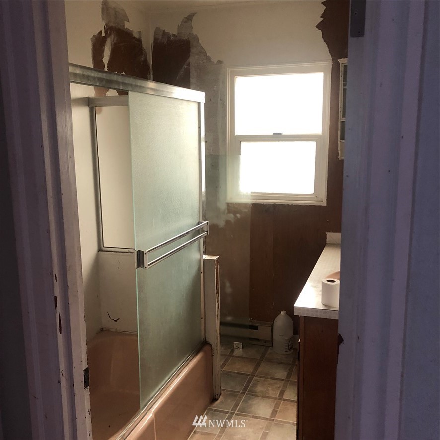 1311 McClellan Street Aberdeen, WA 98520 - Photo 15 of 29 a bathroom with a glass shower door and a sink