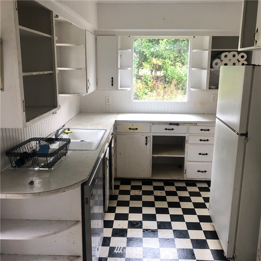 1311 McClellan Street Aberdeen, WA 98520 - Photo 7 of 29 a kitchen with a sink a stove a refrigerator and a window