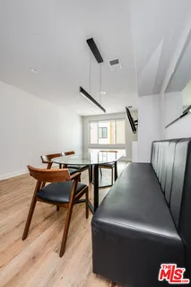 a living room with a table chairs and a wooden floor