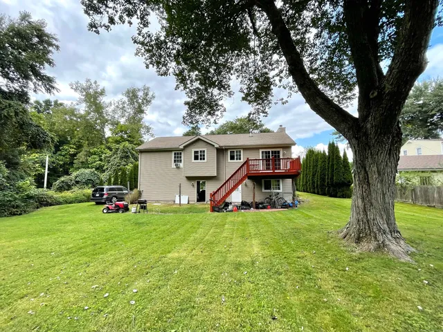 a aerial view of a house with a yard plants and large tree