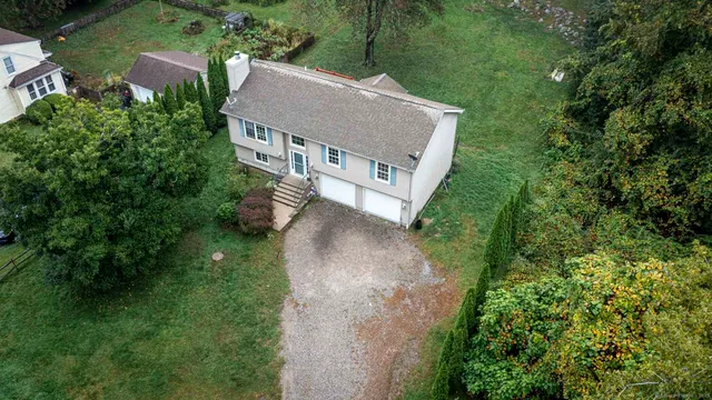 an aerial view of a house with a yard basket ball court and outdoor seating
