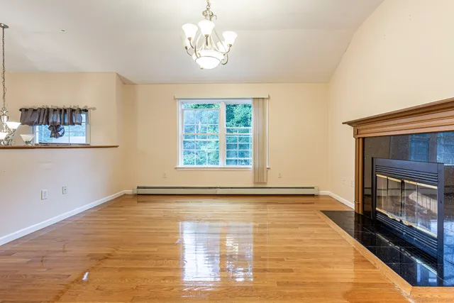 a view of an empty room with a fireplace and a window