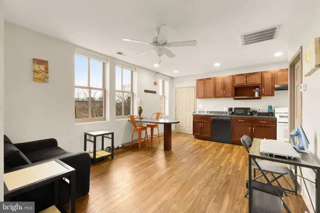 a kitchen with stainless steel appliances granite countertop a sink a stove a refrigerator cabinets and a window