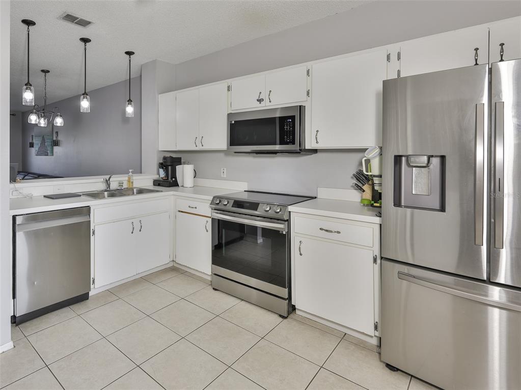 477 Countryside Key Boulevard Oldsmar, FL 34677 - Photo 16 of 46 a kitchen with white cabinets stainless steel appliances and sink