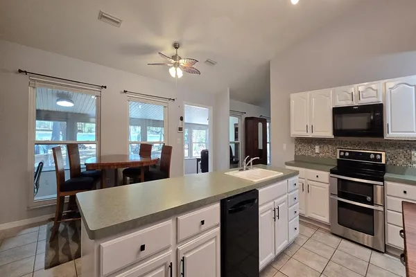 a kitchen with stainless steel appliances a sink dishwasher stove refrigerator and cabinets