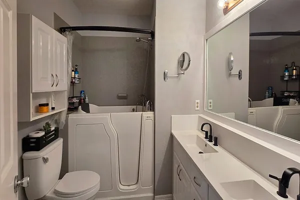 a bathroom with a sink a toilet and shower