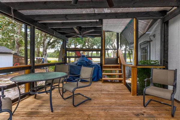 a view of a porch with furniture and a yard