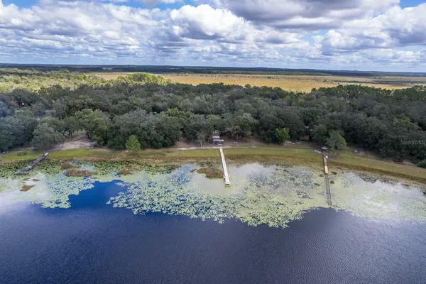 a view of a swimming pool with a yard and a bench