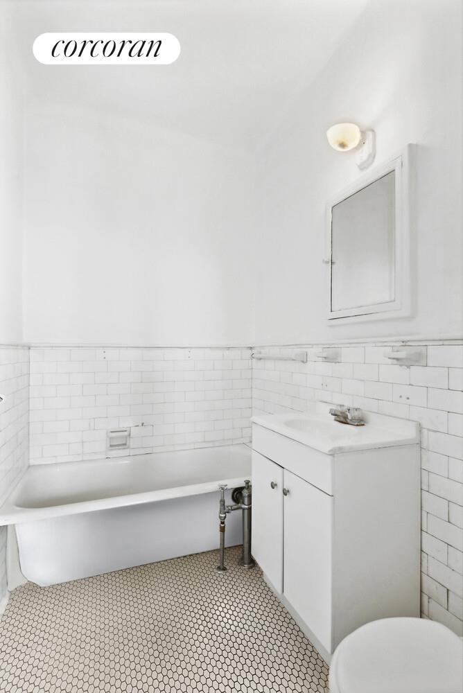 409 Edgecombe Avenue, Unit 2A Manhattan, NY 10032 - Photo 13 of 19 a bathroom with a sink a toilet and vanity
