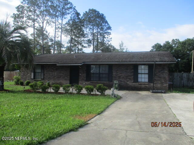 716 Shortputt Drive Macclenny, FL 32063 - Photo 2 of 24 a front view of a house with a garden and yard