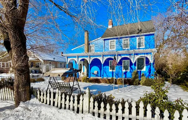 a view of an empty room with wooden floor and furniture