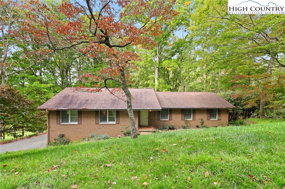 a view of house with yard and outdoor seating