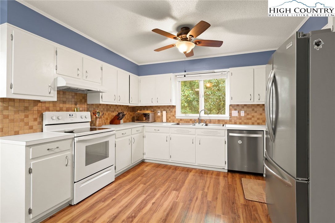 357 Kalmia Lane Boone, NC 28607 - Photo 11 of 41 a kitchen with a stove white cabinets and white appliances