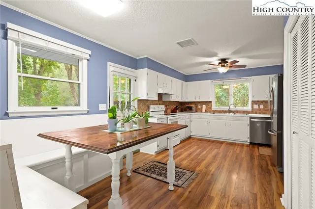 a kitchen with a table chairs refrigerator and window