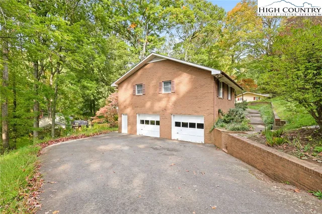 a view of a house with a yard and large tree
