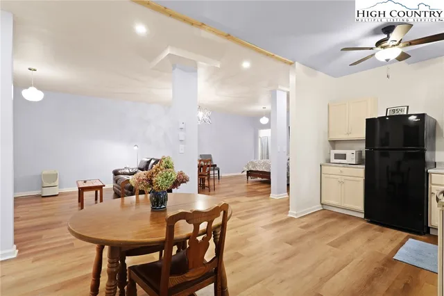 a kitchen with a dining table chairs and refrigerator