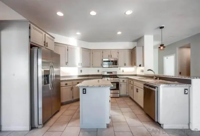 a kitchen with stainless steel appliances granite countertop a stove top oven a sink and a refrigerator