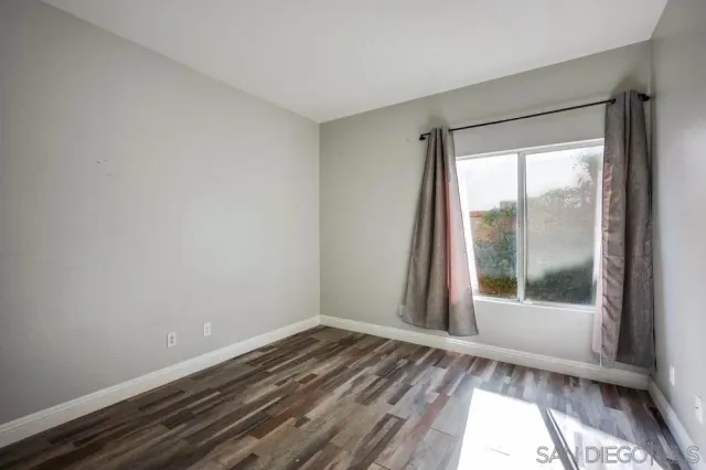 a view of a room with wooden floor and a window