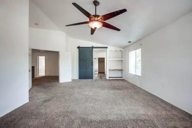 a view of a livingroom with a ceiling fan and window