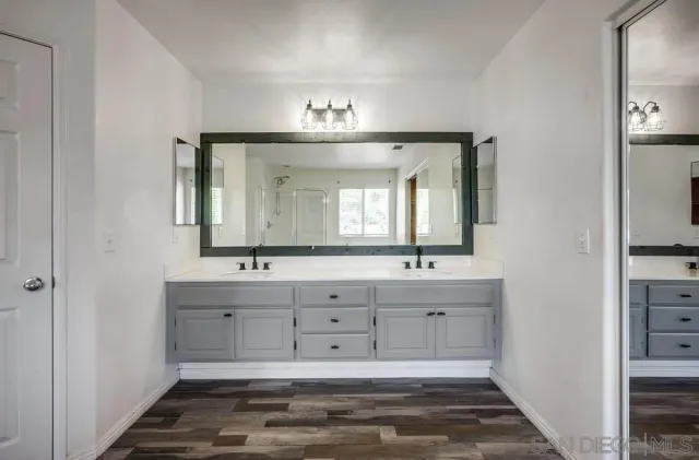 a bathroom with double vanity sink and a mirror