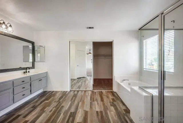 a bathroom with a sink a toilet and a large mirror