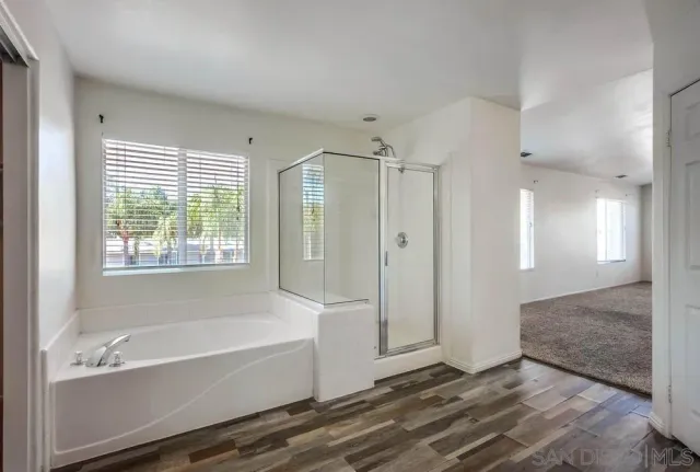 a bathroom with a tub shower and sink