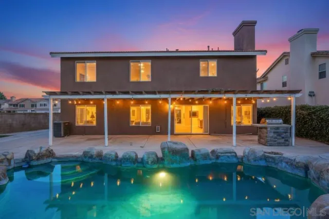 a front view of a house with swimming pool and furniture
