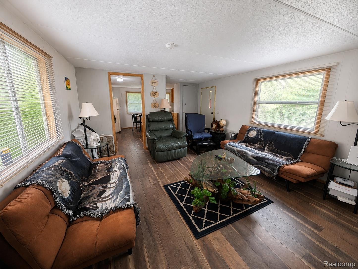 643 North Hockaday Road Gladwin, MI 48624 - Photo 4 of 24 Open-concept living space with wood-finish flooring, multiple windows providing natural illumination, and white walls