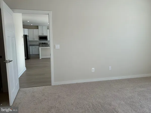 wooden floor in kitchen and an empty room