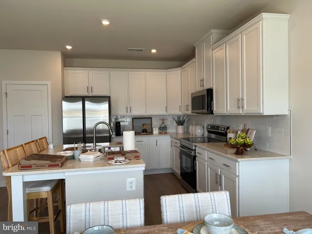 a kitchen with a sink stainless steel appliances and white cabinets