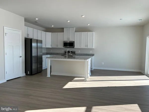 a kitchen with stainless steel appliances granite countertop a sink a stove a refrigerator and cabinets