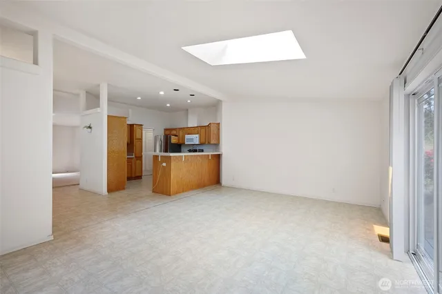 an empty room with kitchen view