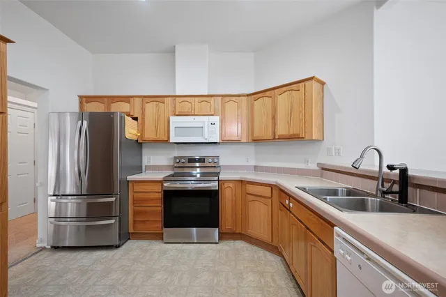 a kitchen with stainless steel appliances granite countertop a refrigerator stove and sink