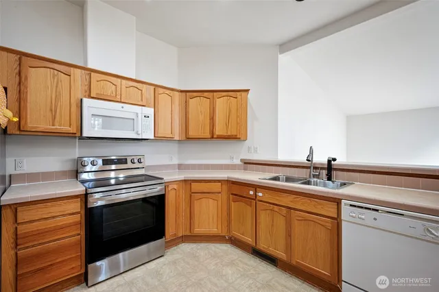 a kitchen with a sink stove top oven and cabinets