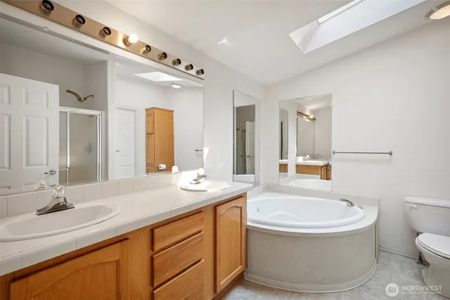 a bathroom with a tub a sink and mirror