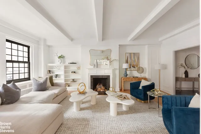 a living room with furniture a fireplace and a large window