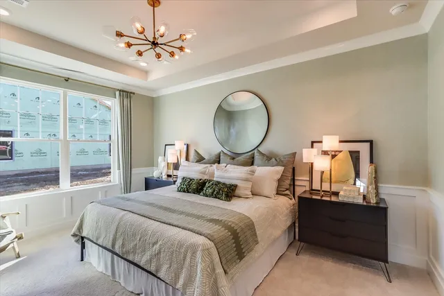 a bedroom with a bed mirror and window