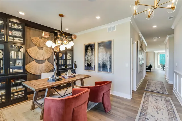 a dining room with furniture a chandelier and wooden floor