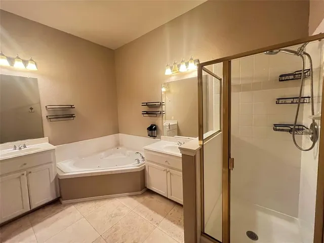 a bathroom with a tub a sink and a large mirror