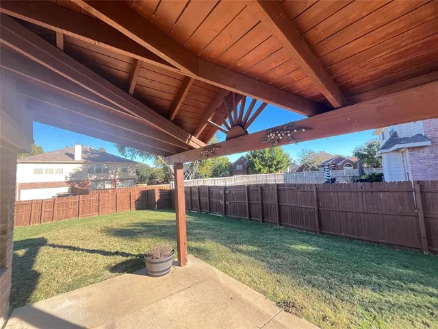 a view of a backyard with wooden fence