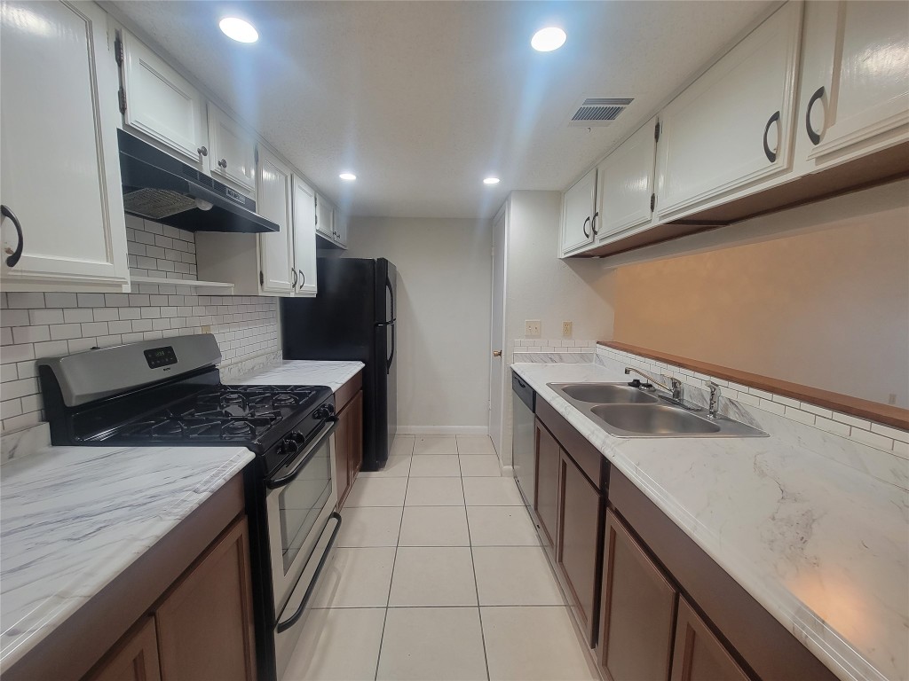 7825 Beauregard Circle, Unit 2A Austin, TX 78745 - Photo 15 of 27 a kitchen with stainless steel appliances granite countertop a sink a stove and a refrigerator