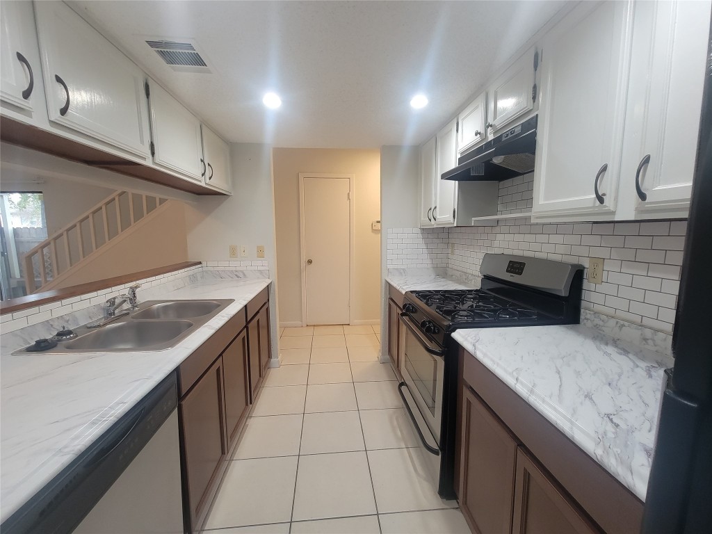 7825 Beauregard Circle, Unit 2A Austin, TX 78745 - Photo 16 of 27 a kitchen with a sink stove and cabinets