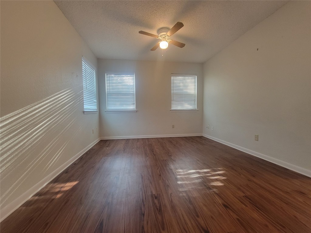 7825 Beauregard Circle, Unit 2A Austin, TX 78745 - Photo 17 of 27 an empty room with wooden floor and windows